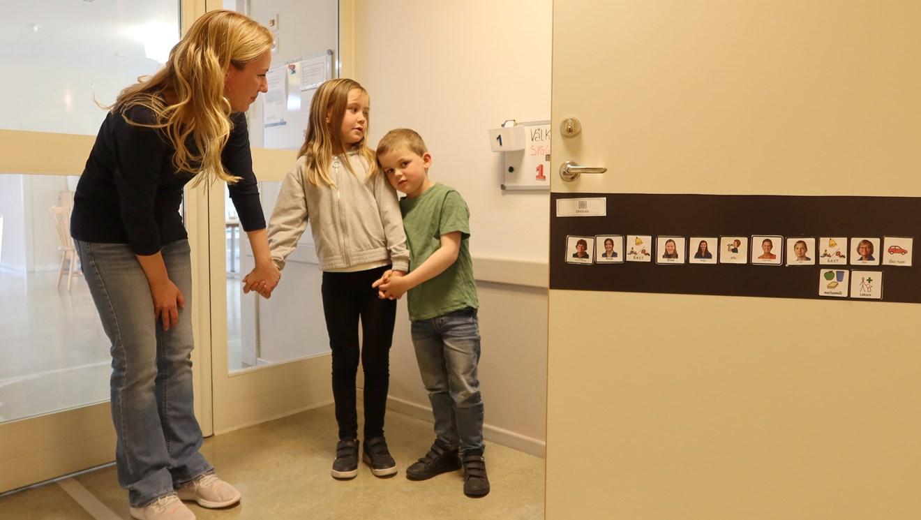En familj framför en dörr med ett bildschema