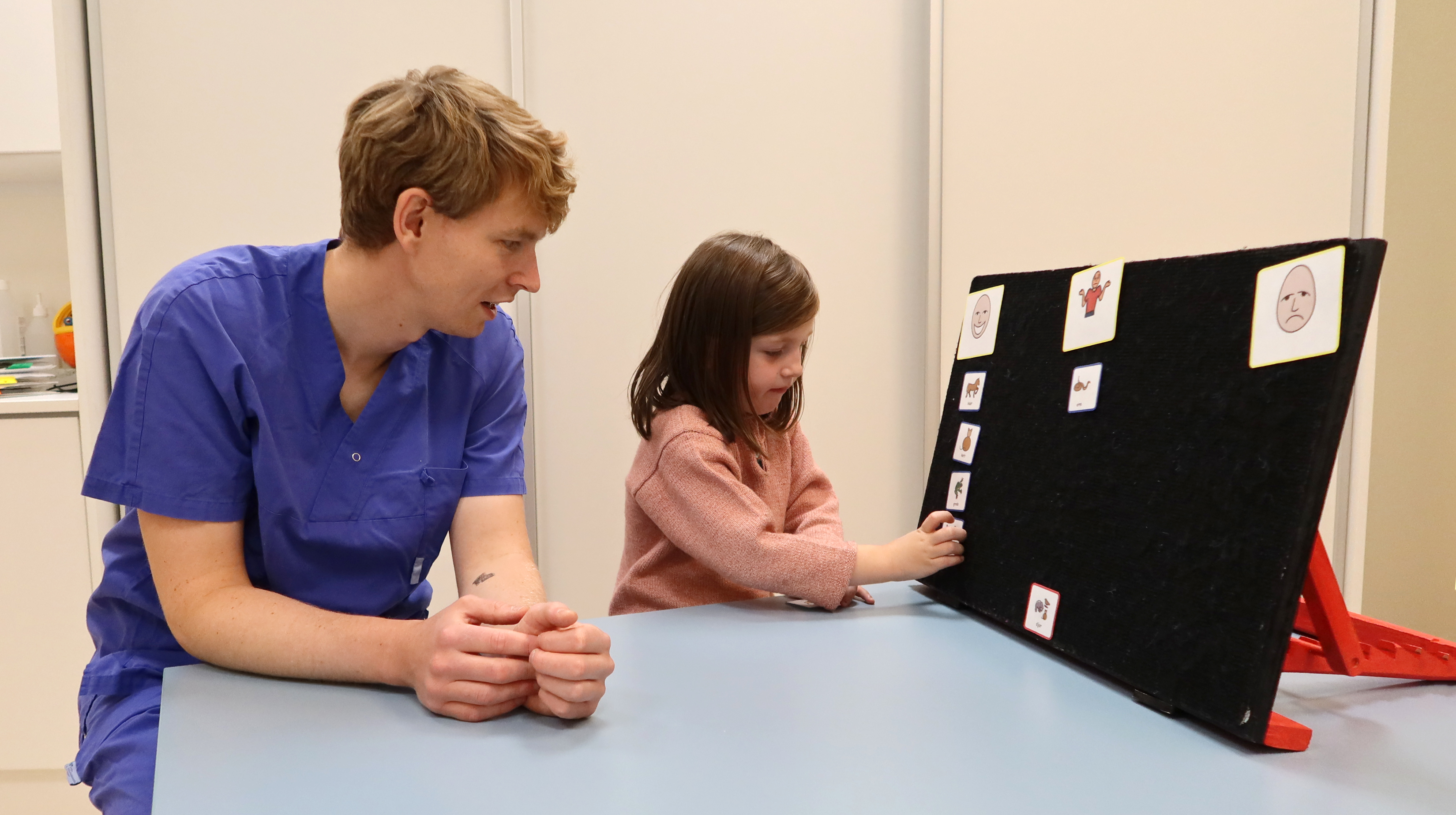 Ett barn sätter kort på en flannellograf