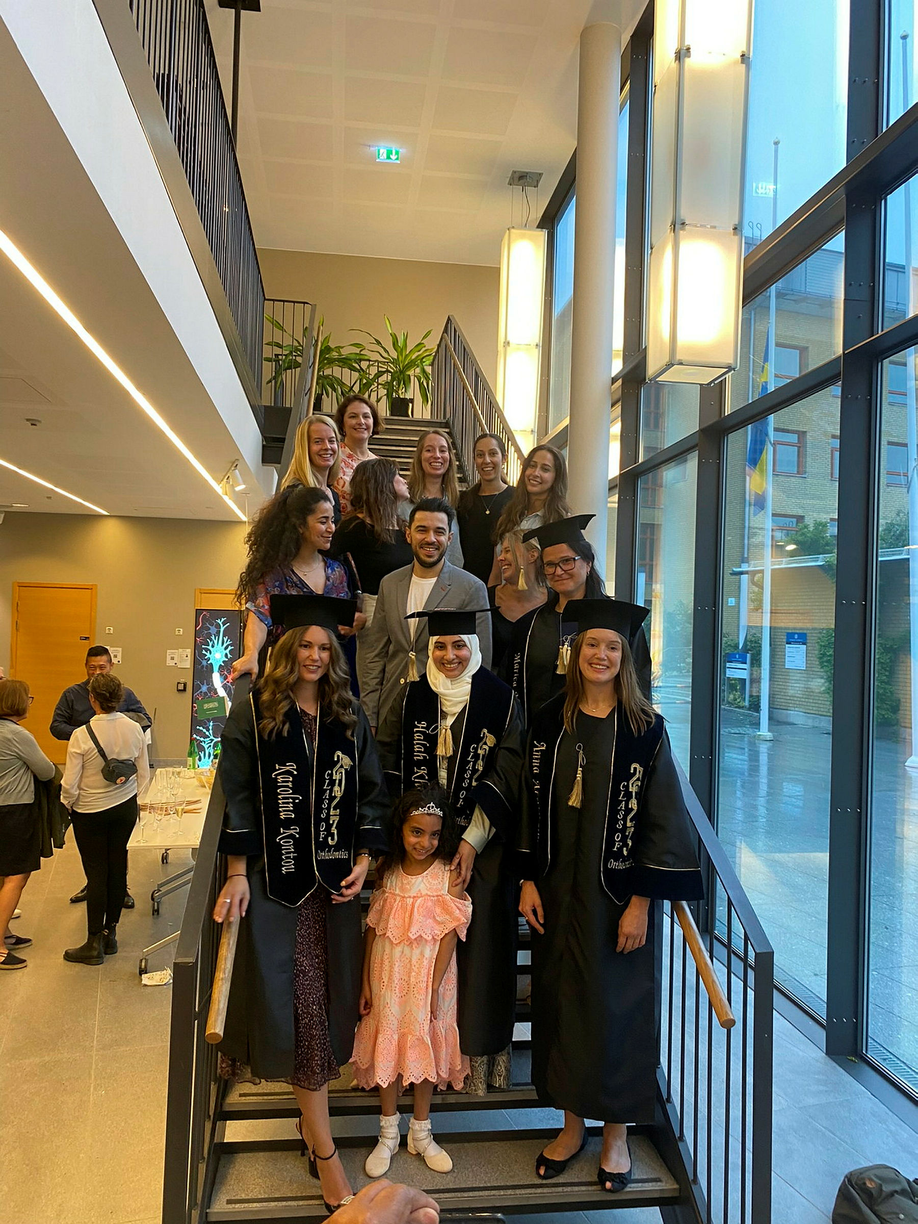 Students in academic gowns standing on the stairs