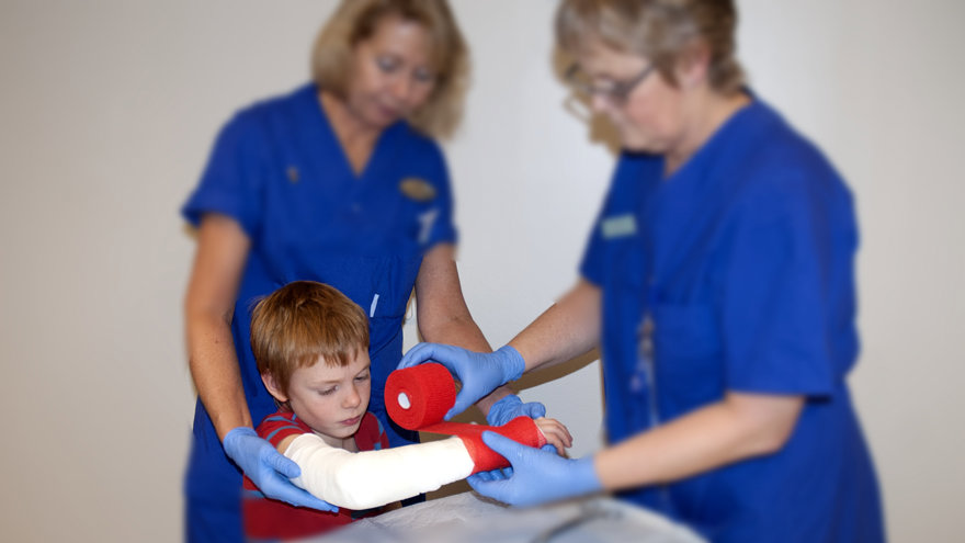 Ett barn får ett rött gips