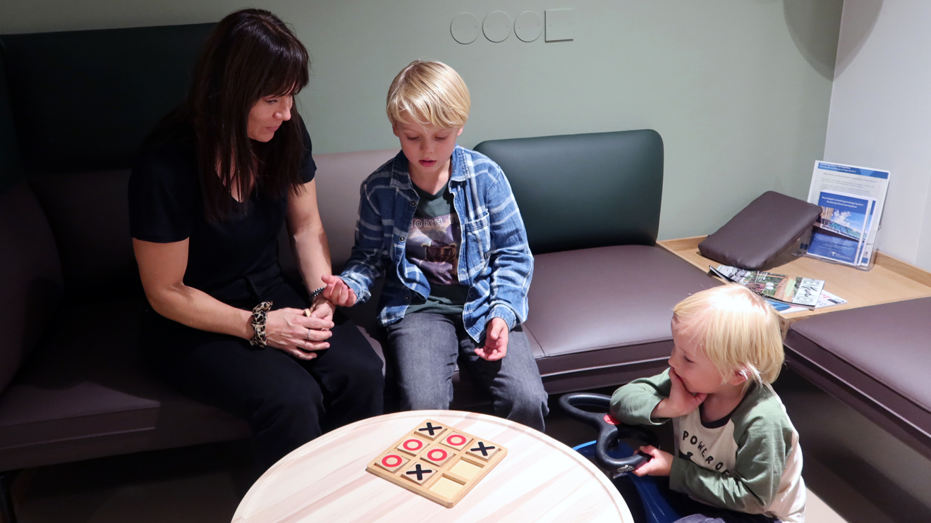 Två barn och en mamma i ett väntrum