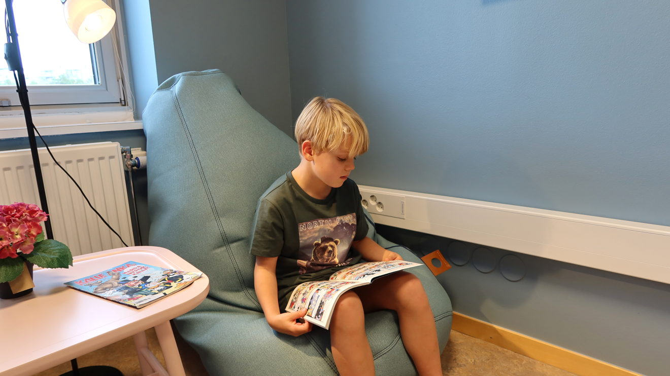 Ett barn sitter i en sacco-säck och läser