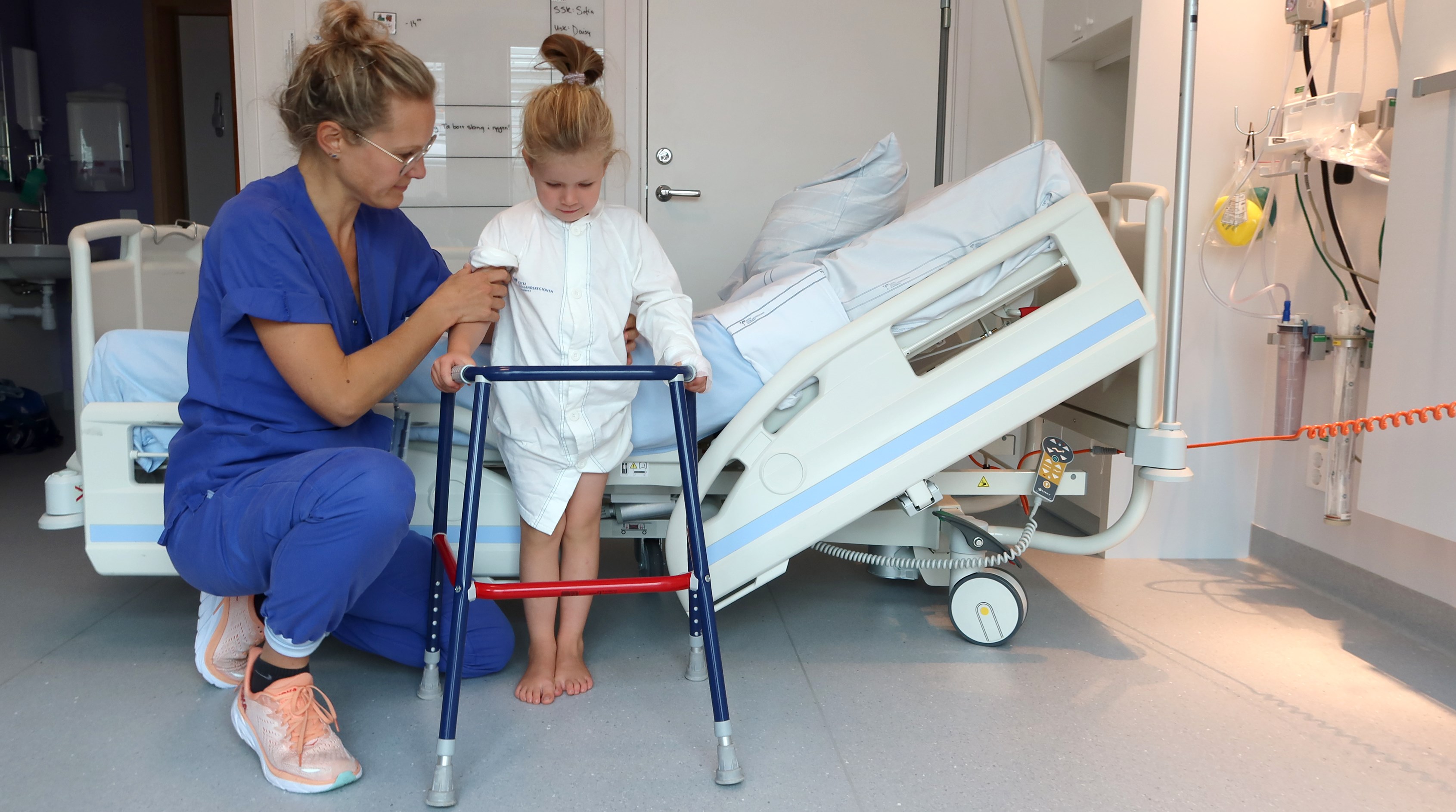 Ett barn får hjälp att komma upp ur sängen