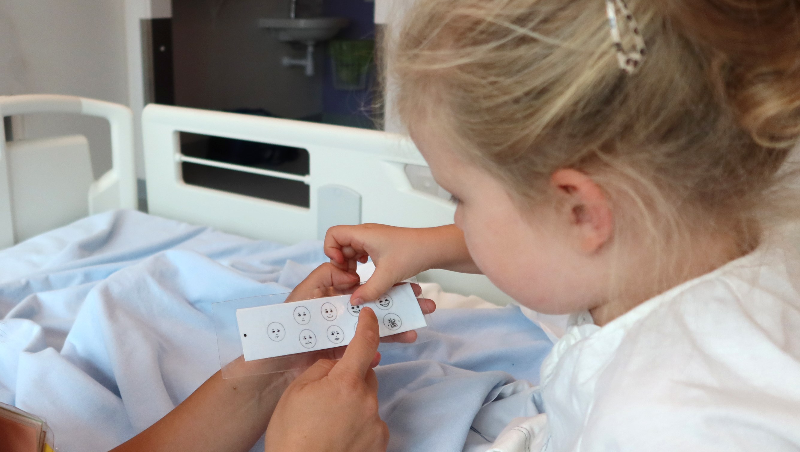 Ett barn pekar på en smärtskala