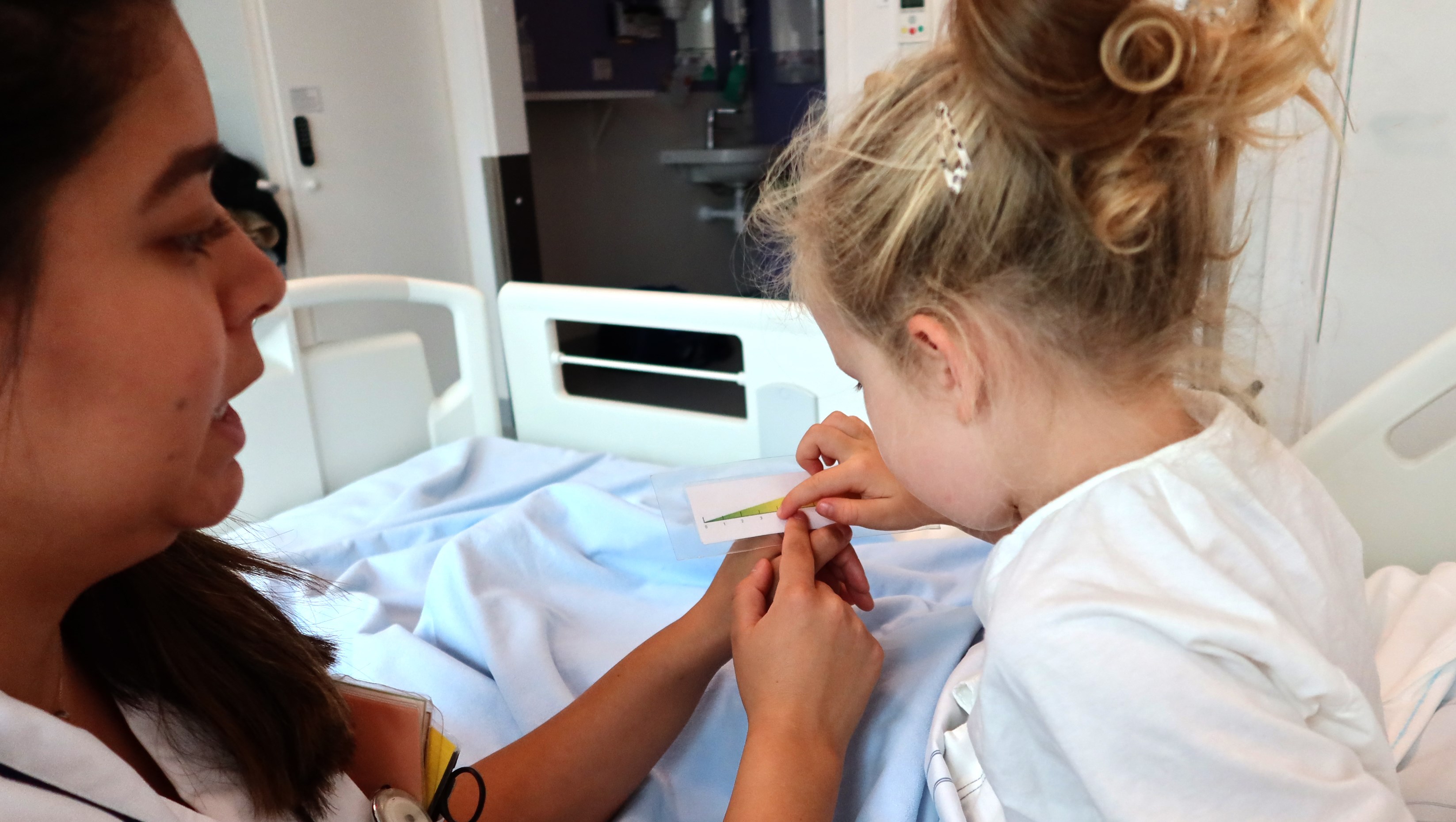 Ett barn pekar på en smärtskala