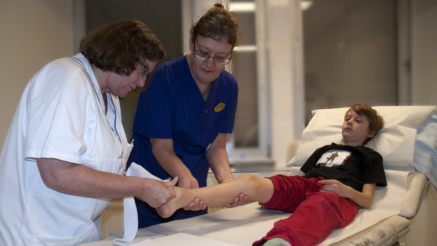 Ett barn får bandage på foten