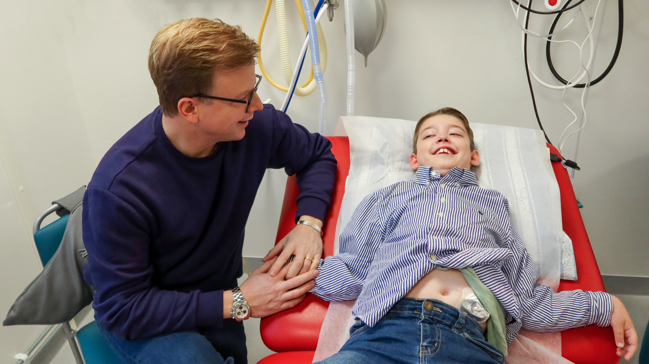 En pojke på en brits med sin pappa