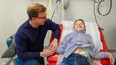 En pojke på en brits med sin pappa