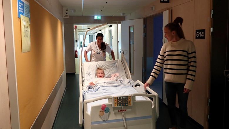 Ett barn åker i en sjukhussäng