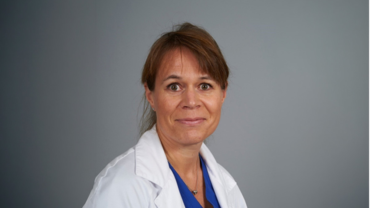 Female medical professional in scrubs and white coat
