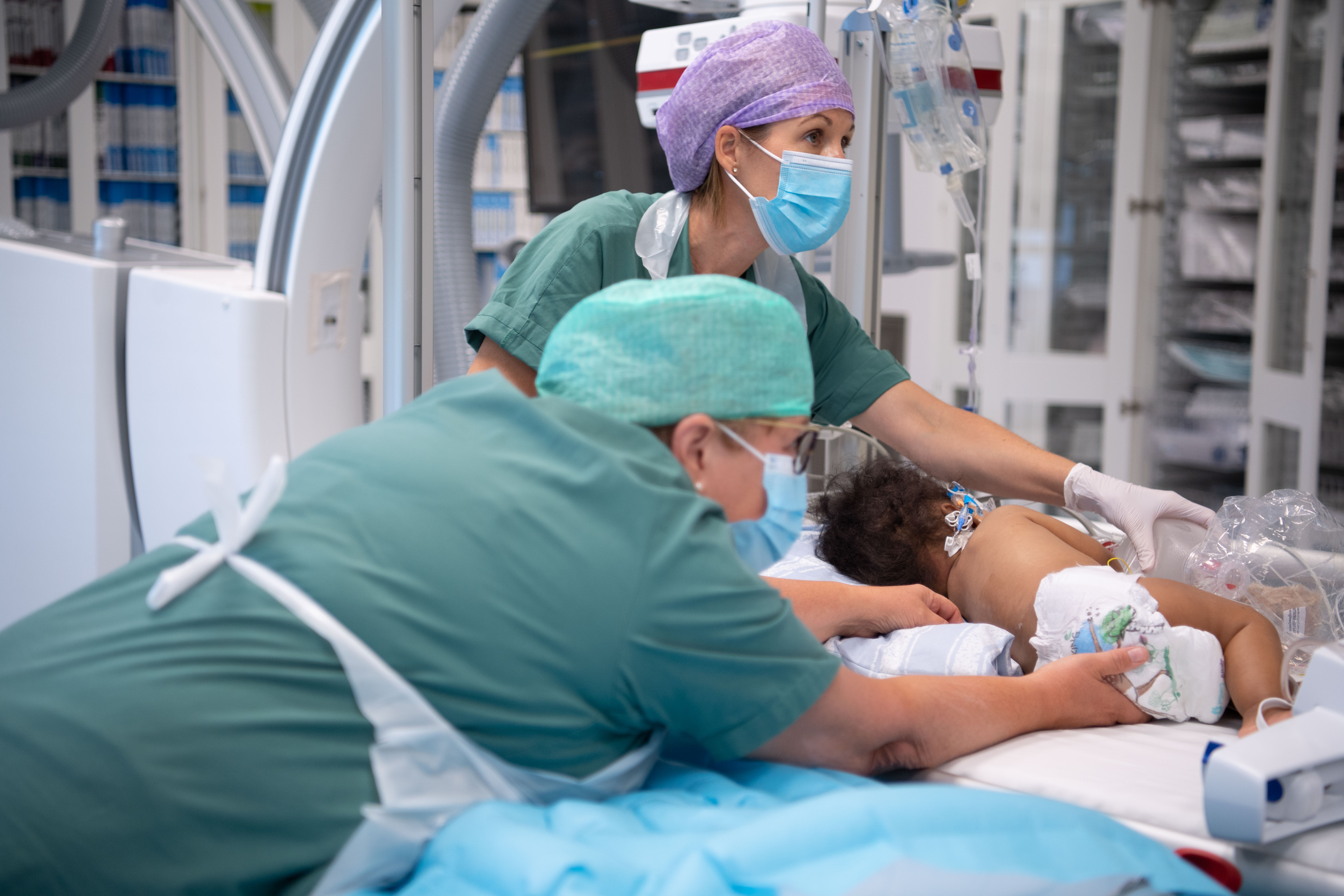 Two doctors treaing a child.
