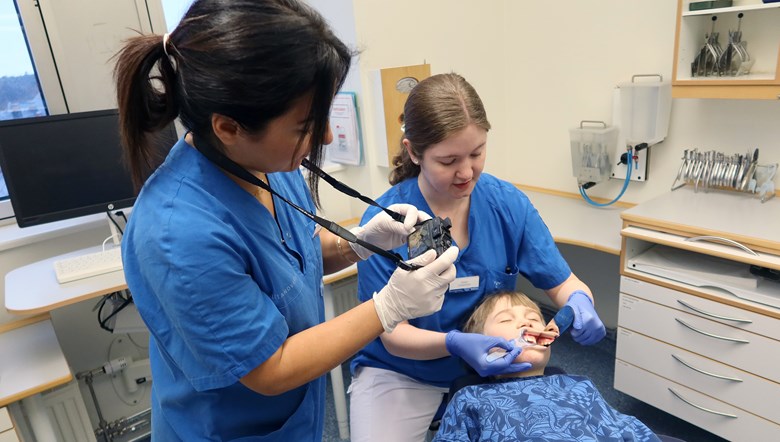 En tandläkare tar ett foto på tänder