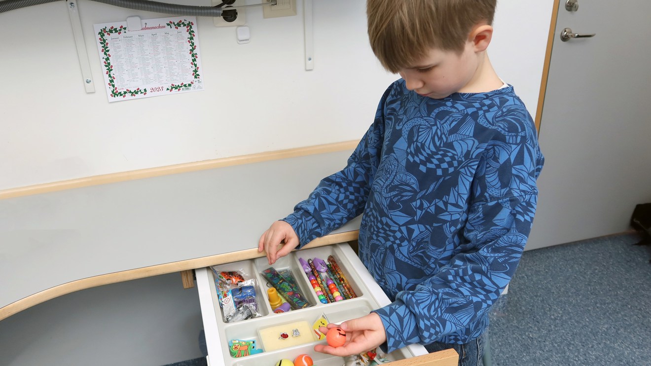 Ett barn väljer en present ur en låda