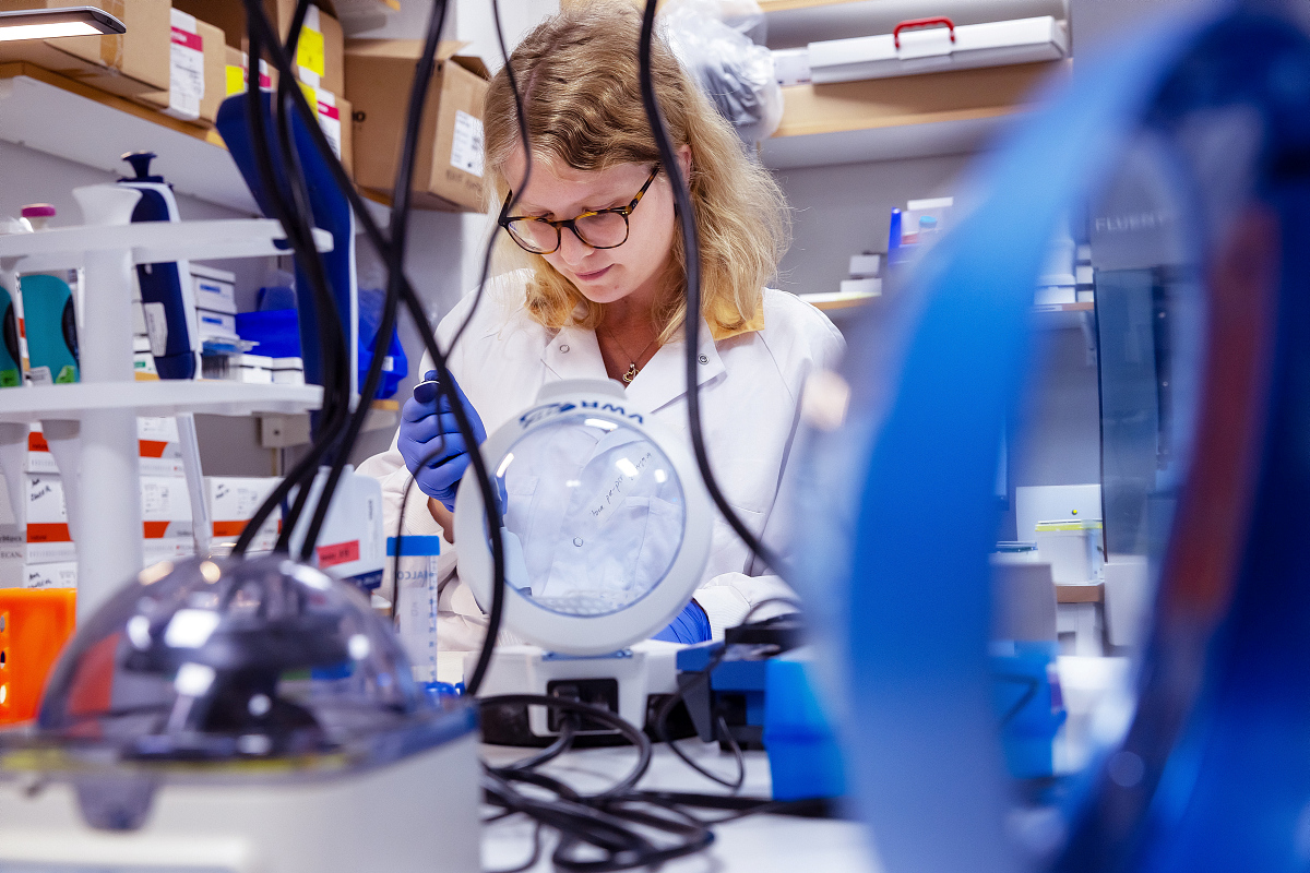 A woman in a lab coat performing tests.