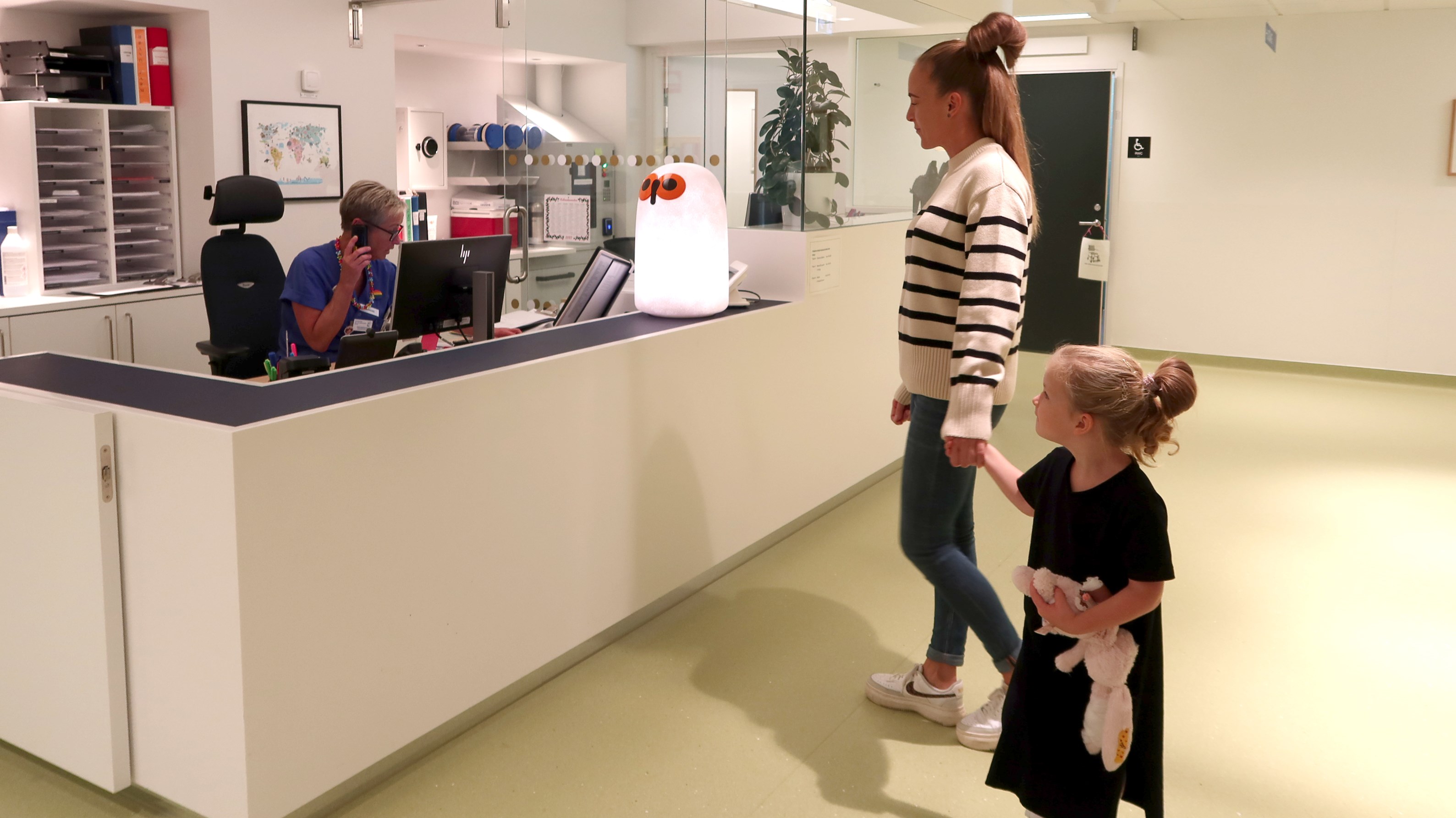 Ett barn ovh en mamma framför en reception