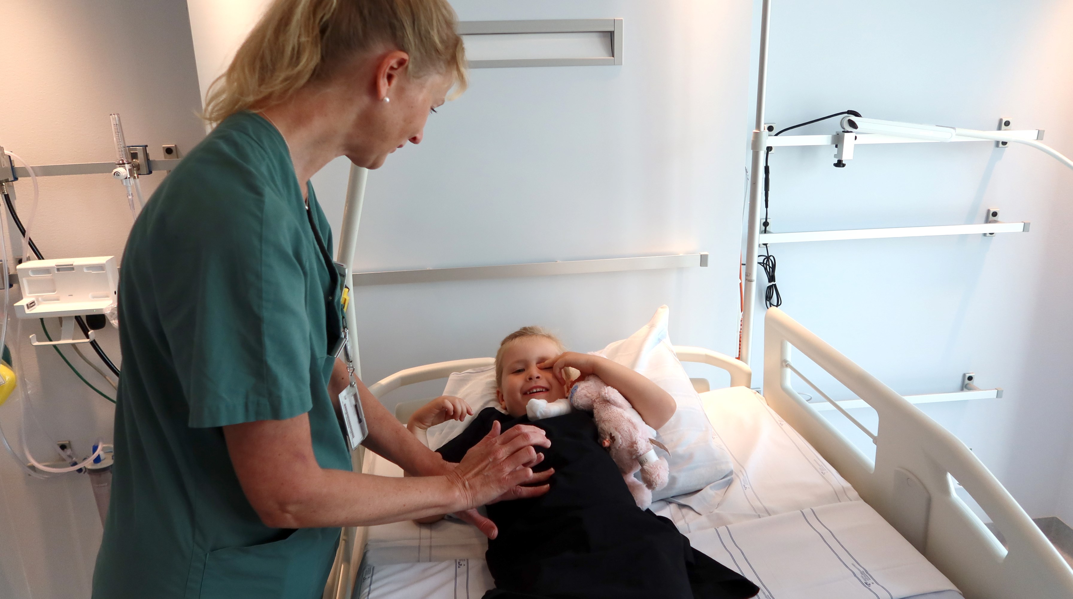 En doktor känner på magen på ett barn