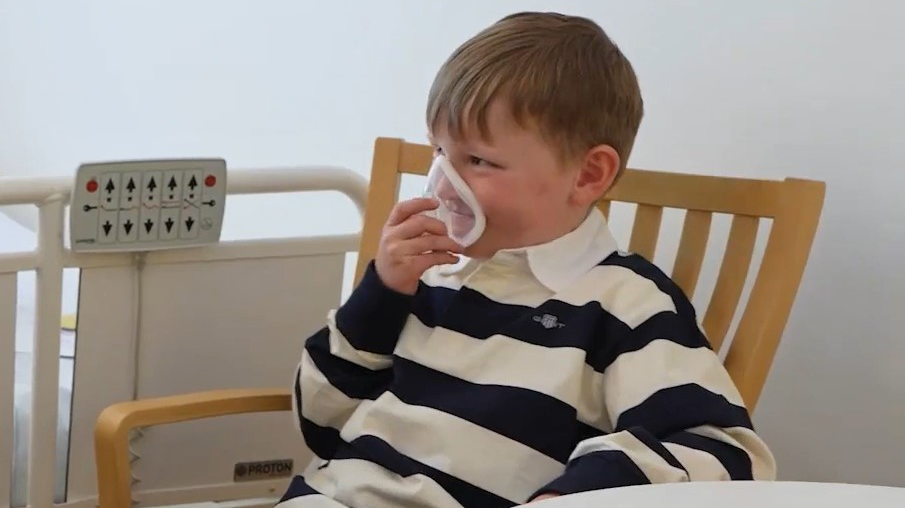 En pojke med en andningsmask