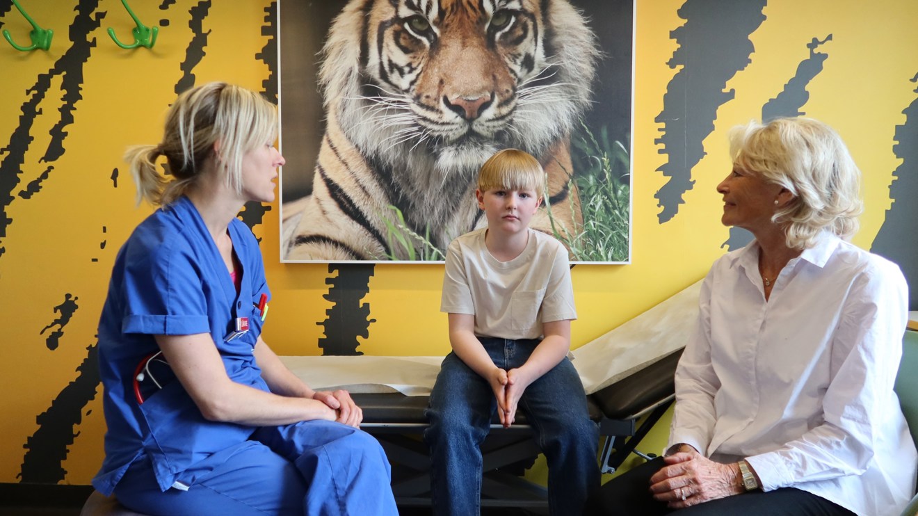 Ett barn och en mormor pratar med en doktor
