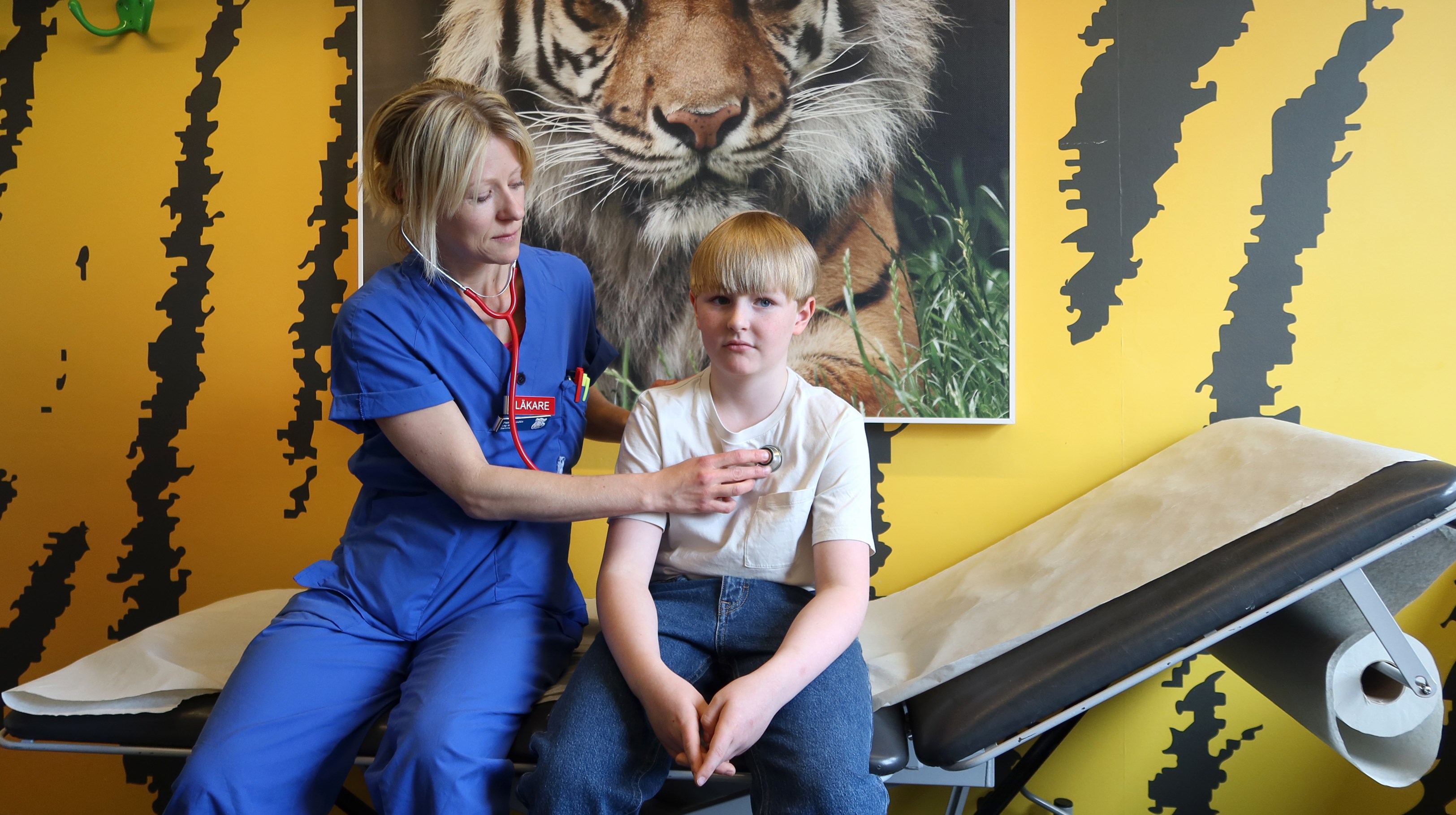 En doktor lyssnar på hjärtat på ett  barn