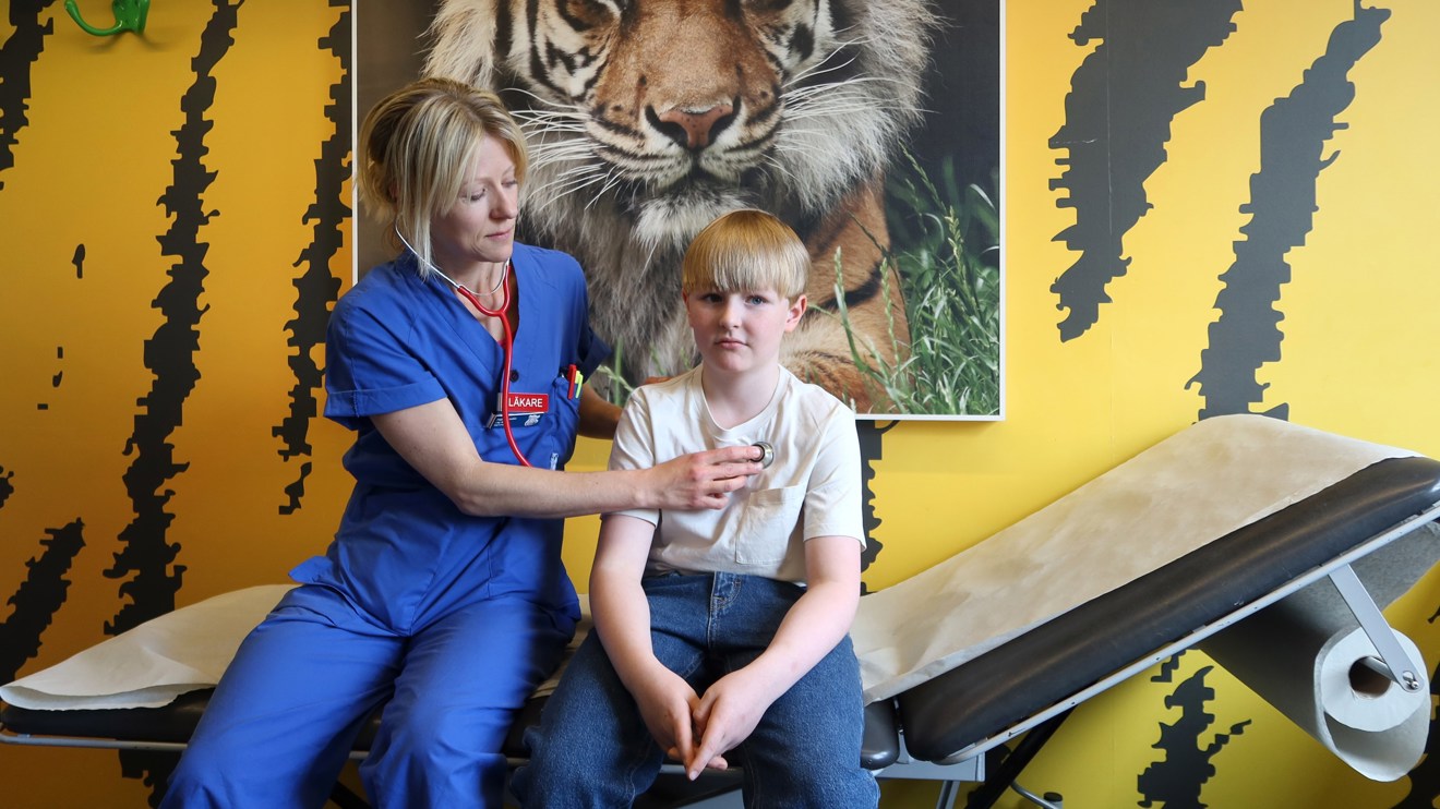 En doktor lyssnar på hjärtat på ett barn