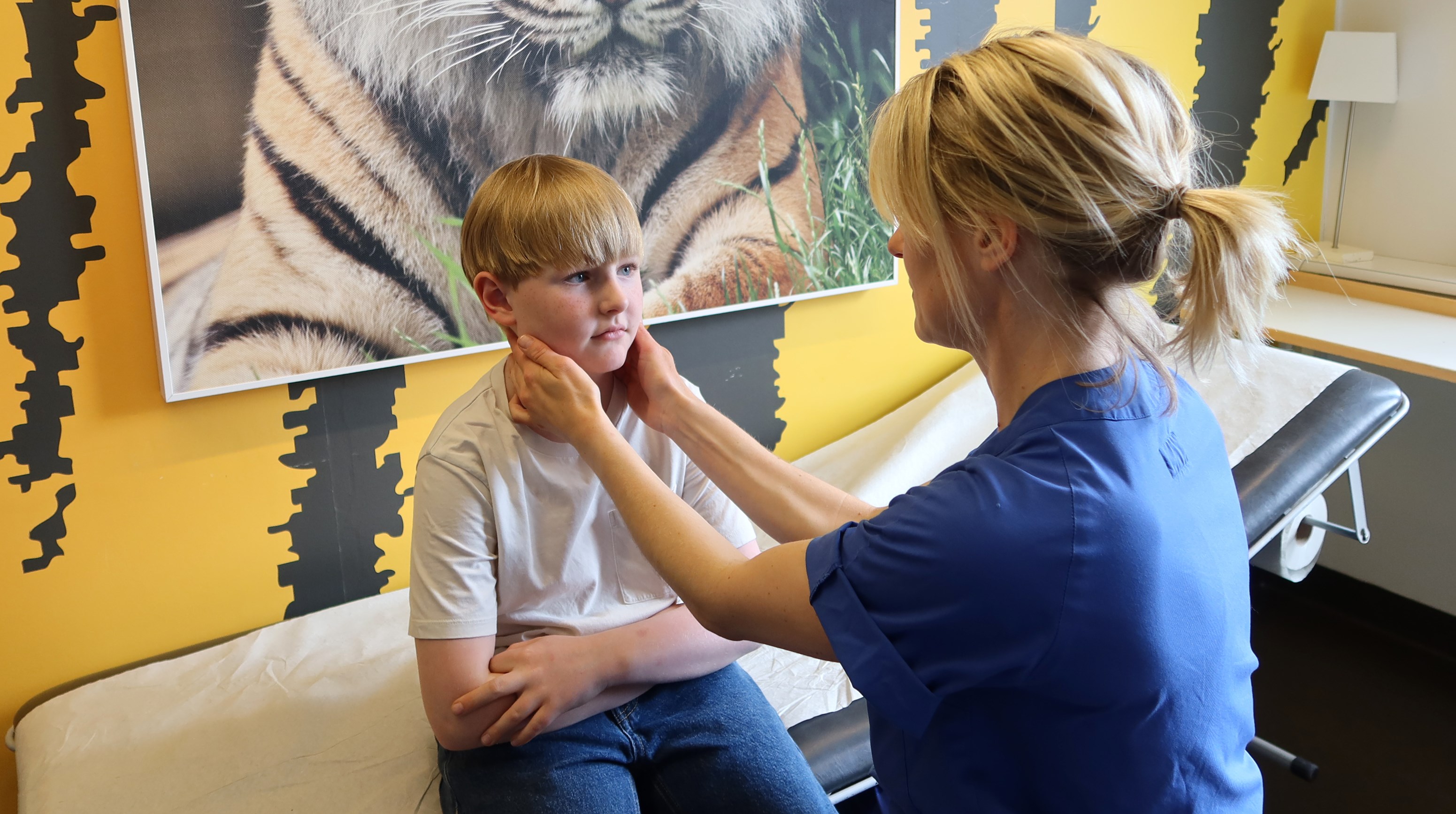 En doktor känner på halsen på ett barn