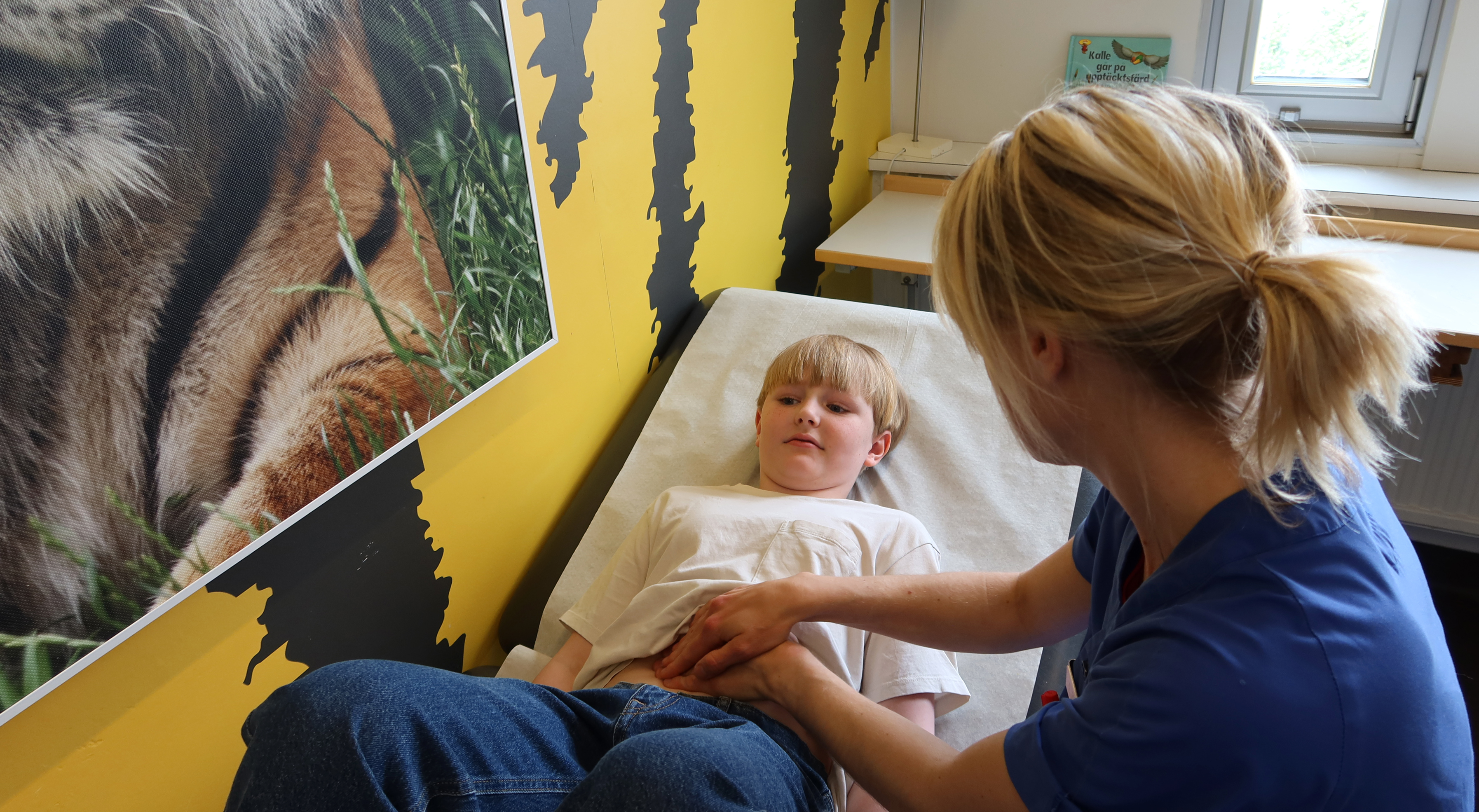 En doktor känner på magen på ett  barn