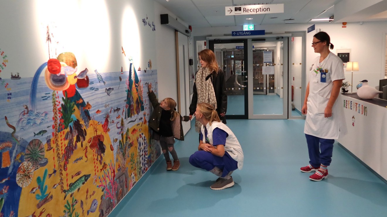 Ett barn pekar på en målning på väggen