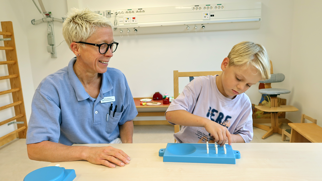 ett barn sätter vita ploppar i en tavla