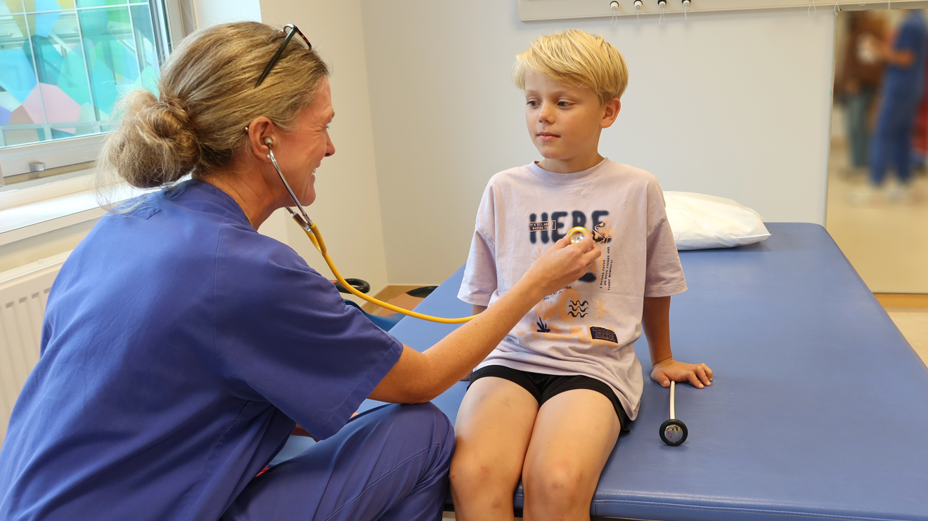 En läkare lyssnar på hjärtat på ett barn