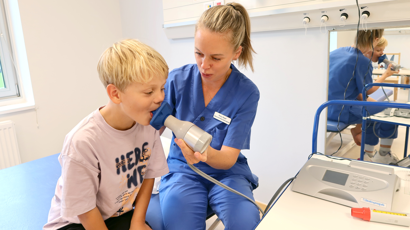 Ett barn blåser i ett munstycke