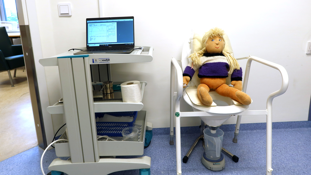 En docka sitter på en toalett