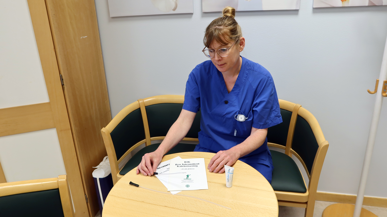 En uroterapeut visar broschyrer