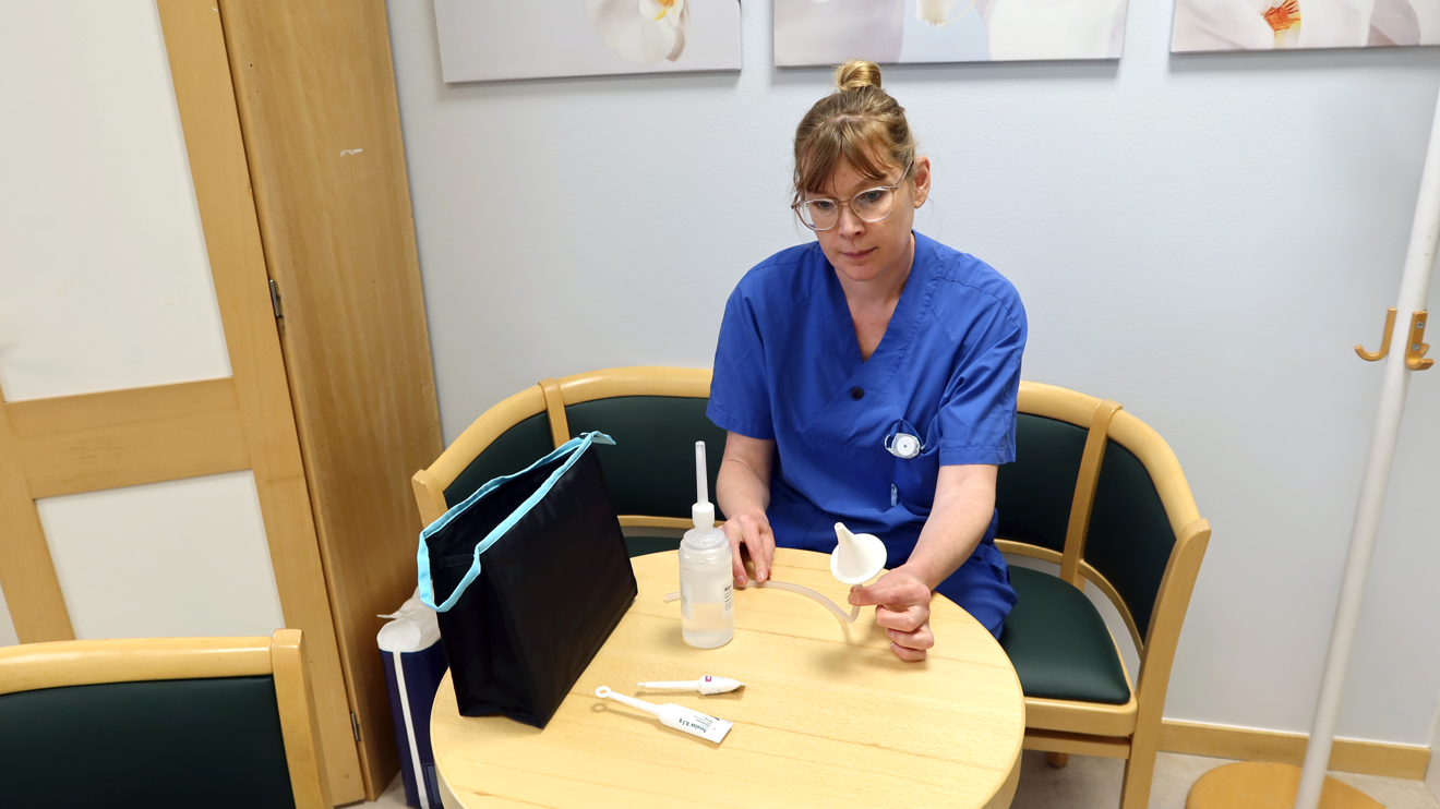 En uroterapeut visar hjälpmdel