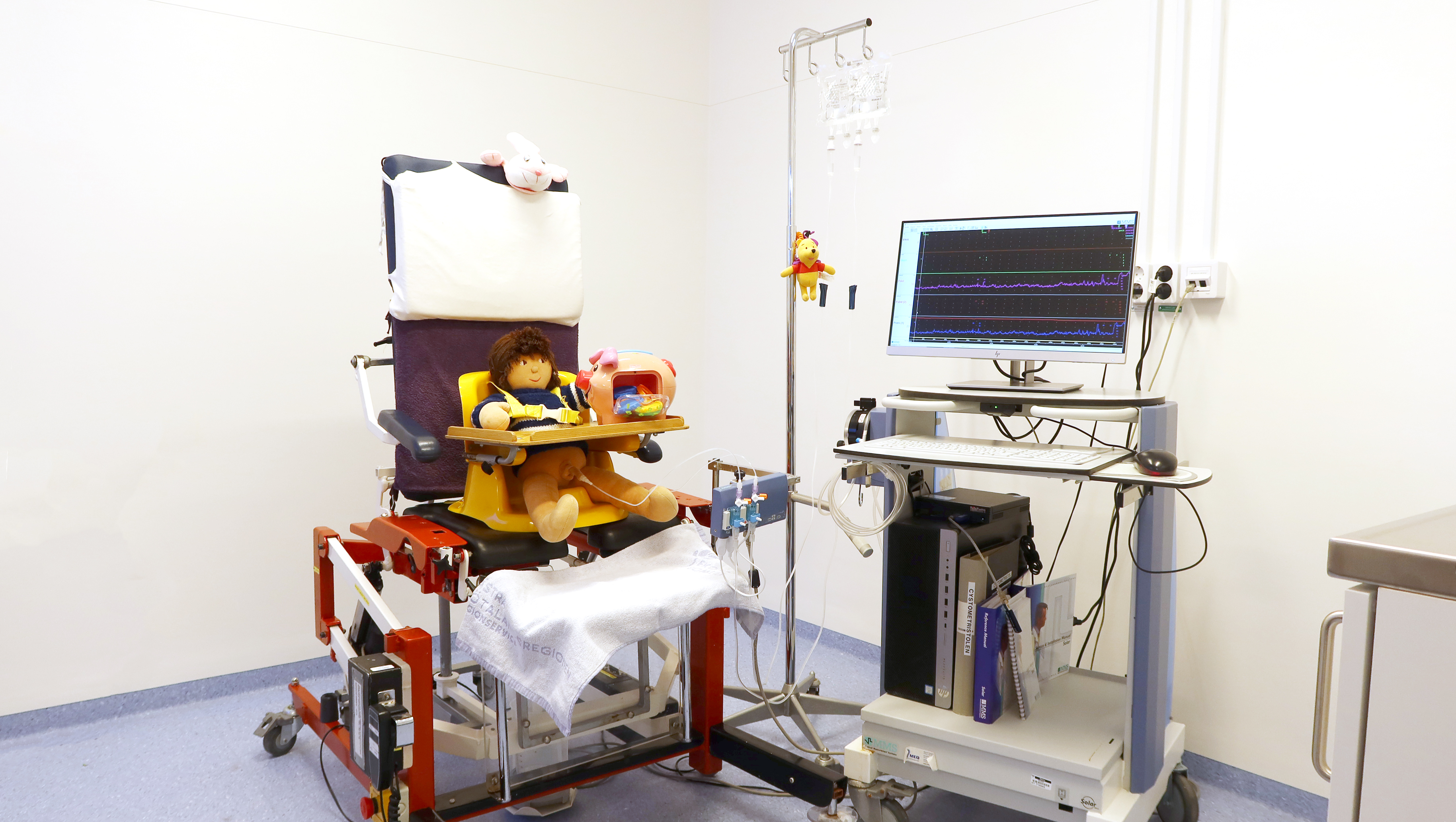 En docka på en stol med apparater runtomkring