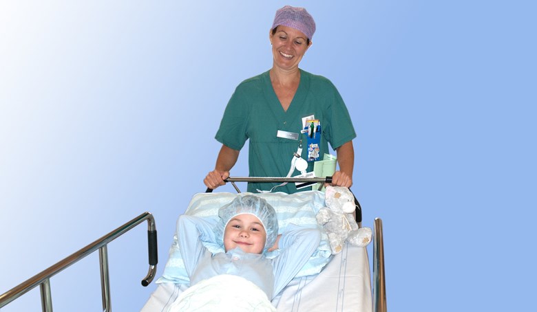 Ett barn med operationsmössa i en säng