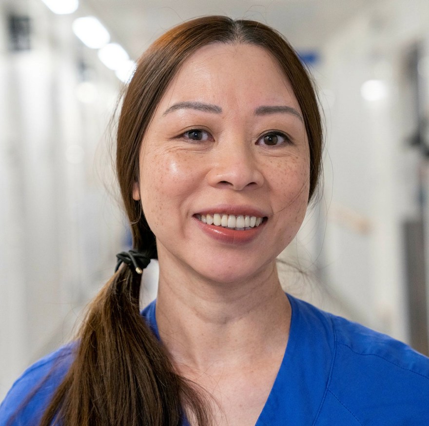 porträtt av undersköterska i sjukhuskorridor.