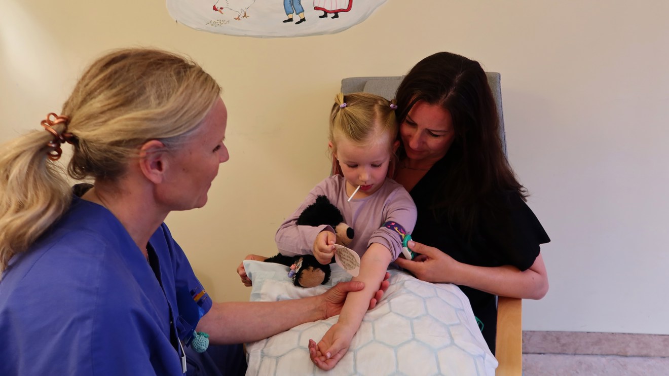 Ett barn tar bort ett plåster på armen