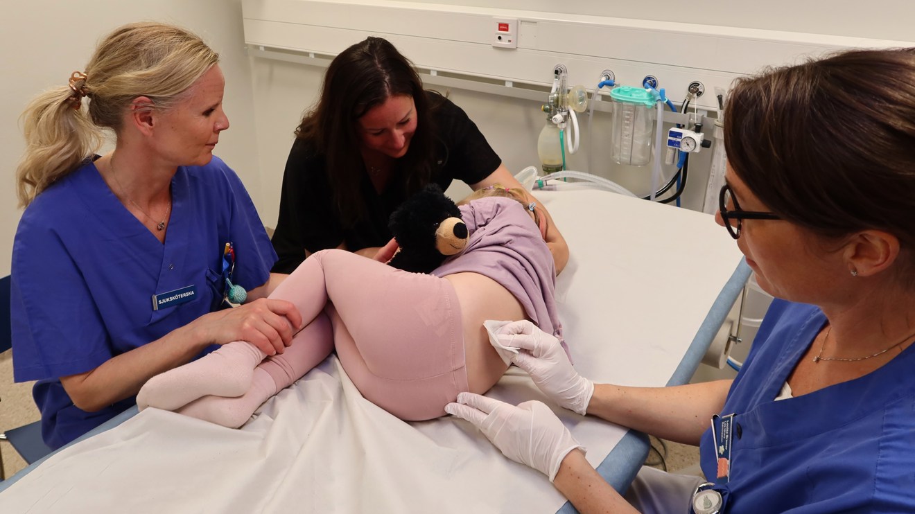 Ett barn blir torkat på ryggen med en sudd