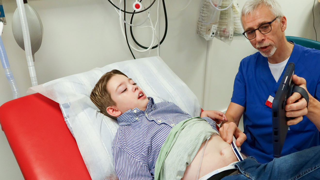 En läkare visar en skärm för en pojke