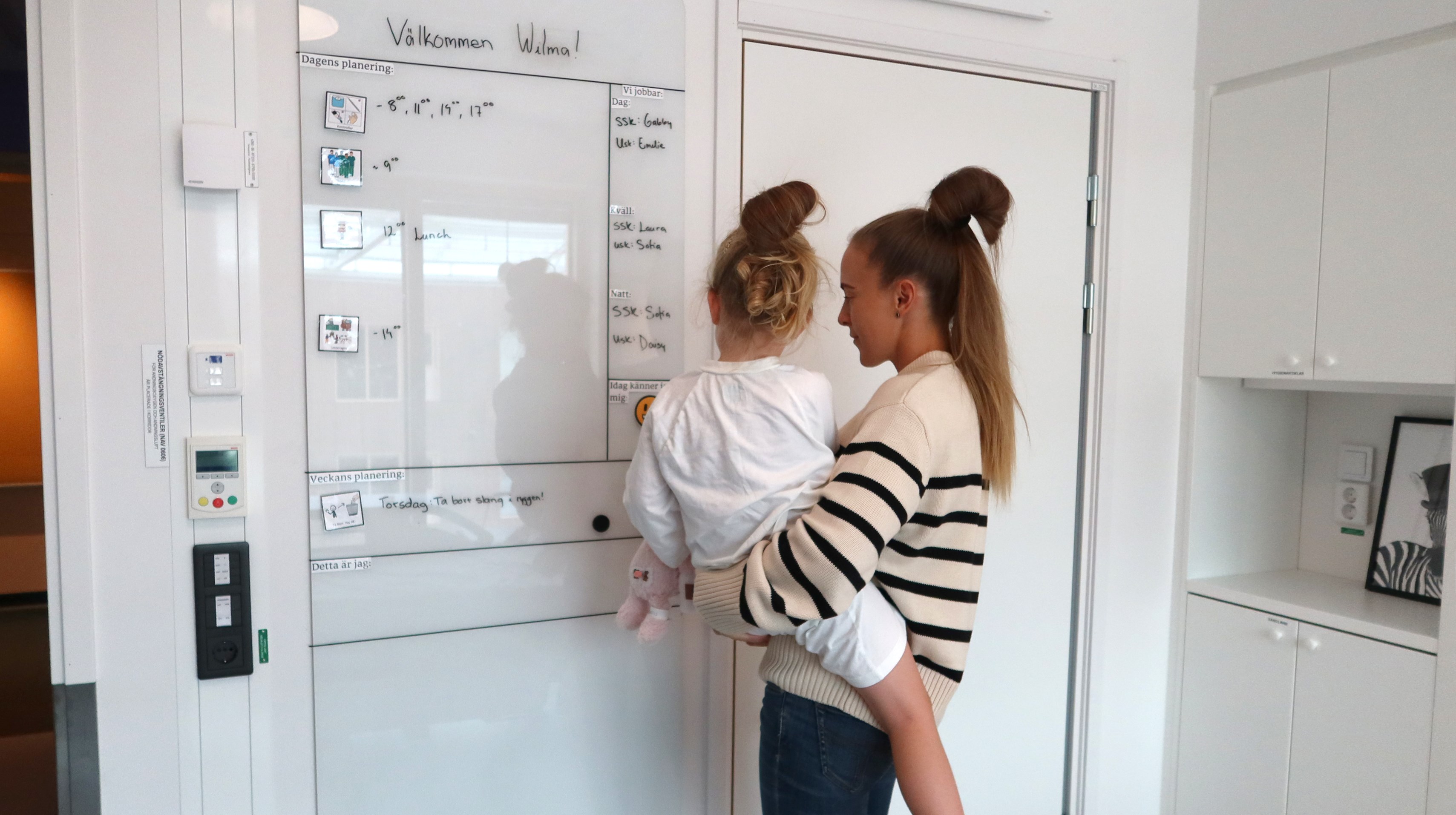 Ett barn och en mamma tittar på en planeringstavla
