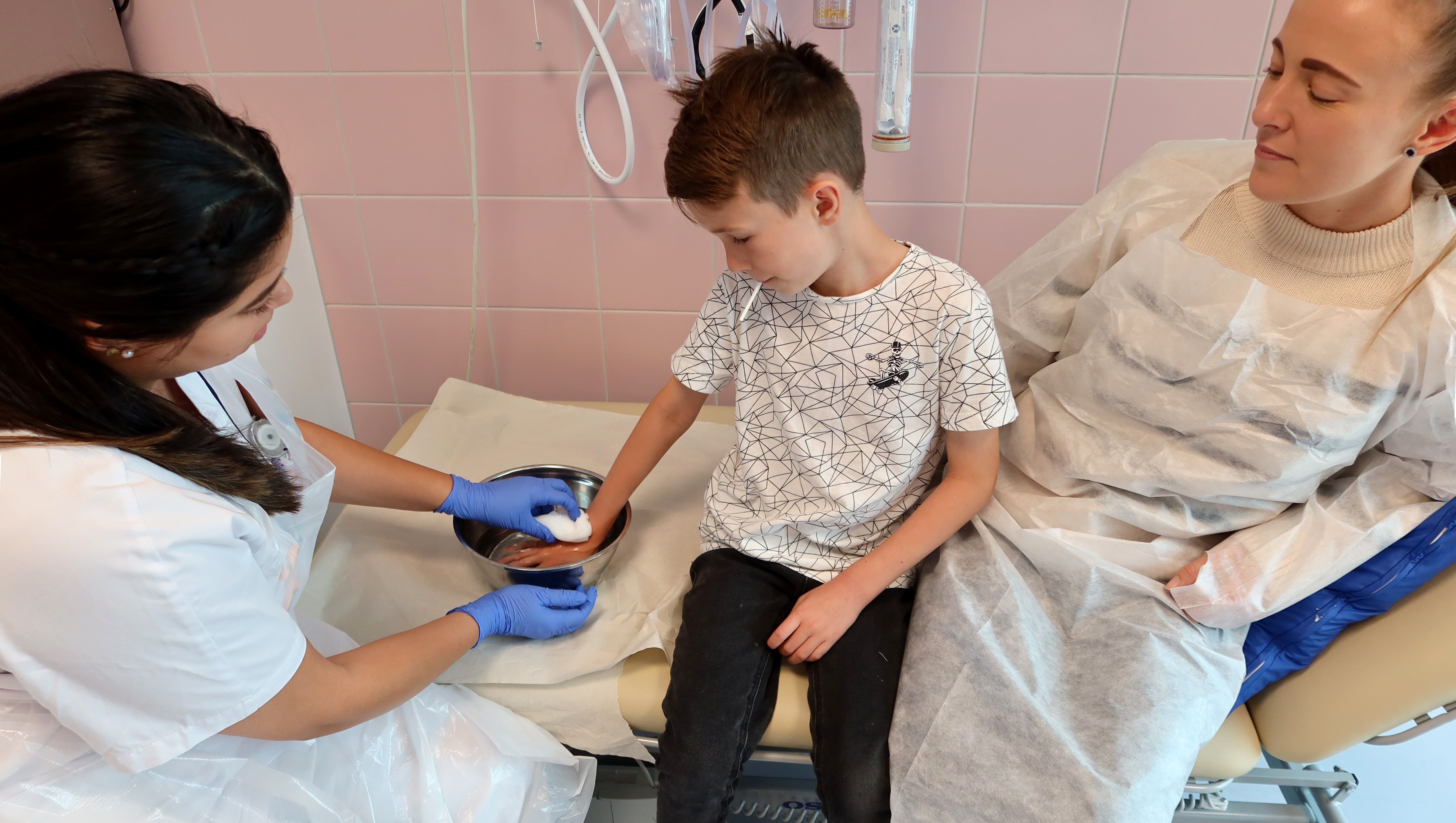 En sjuksköterska tvättar handen på ett barn