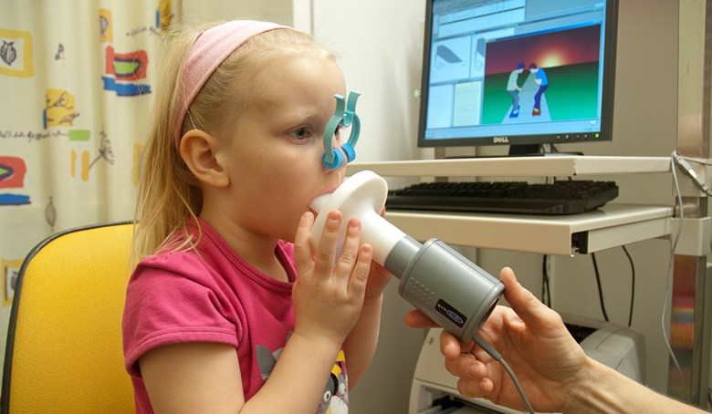 Ett barn blåser i en spirometer