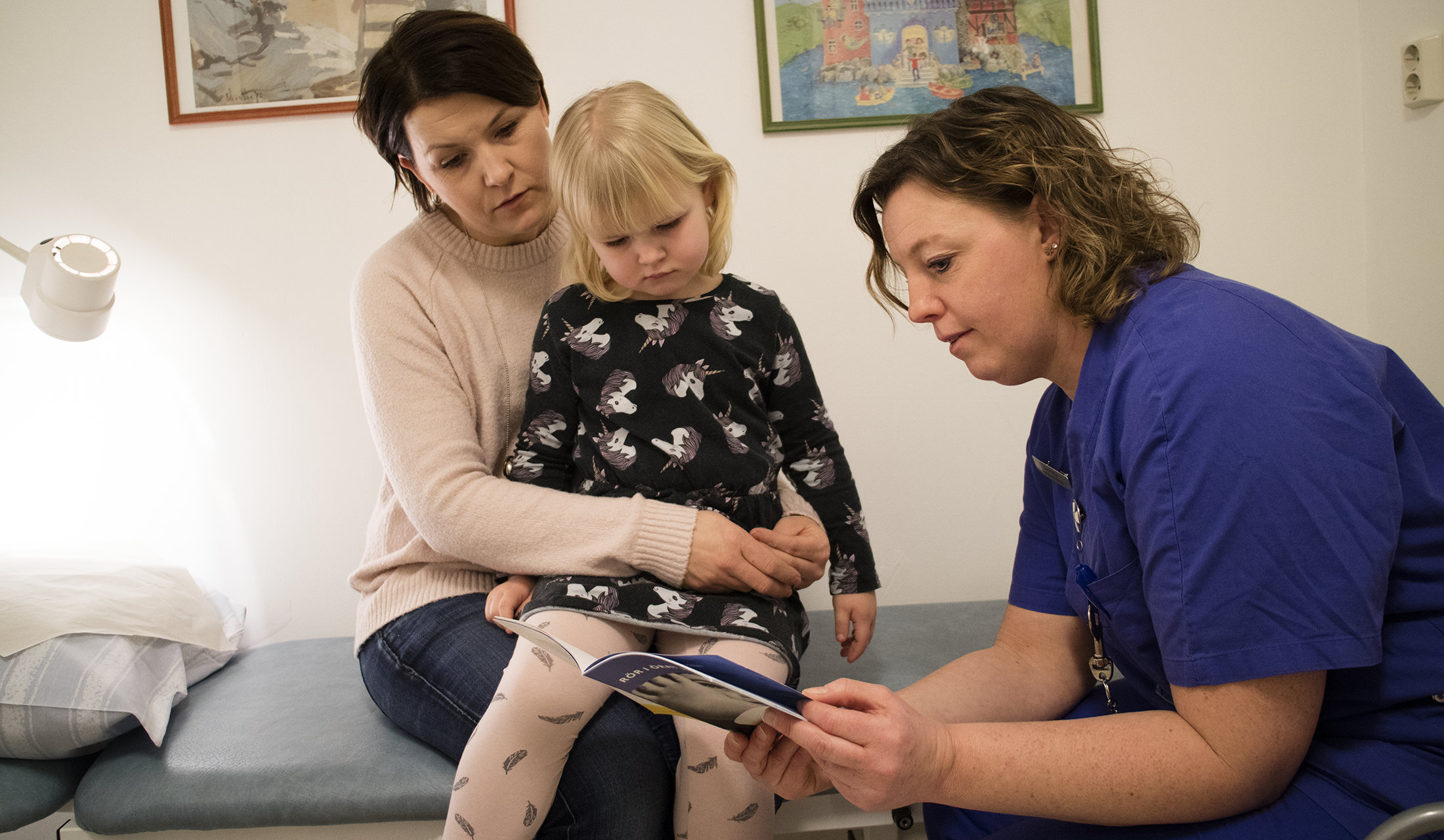 Ett barn och en mamma tittar i en broschyr