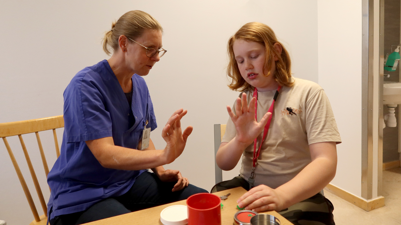 En arbetsterapeut kollar rörligheten i ett barns hand