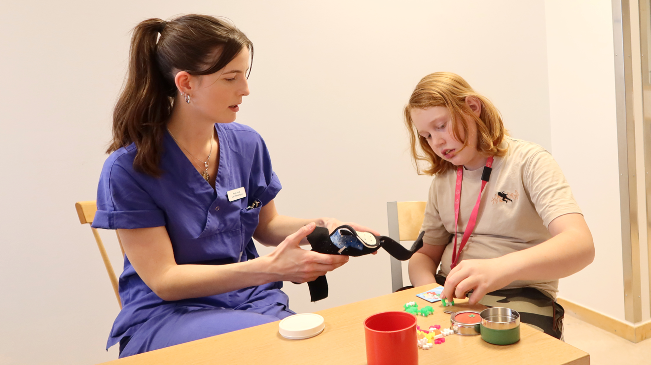 En arbetsterapeut håller fram en ortos