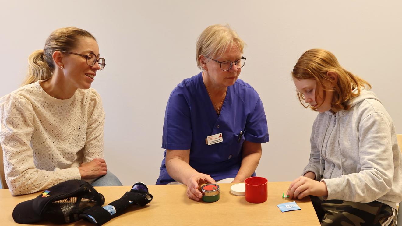 En läkare tittar på hur ett barn använder sin hand