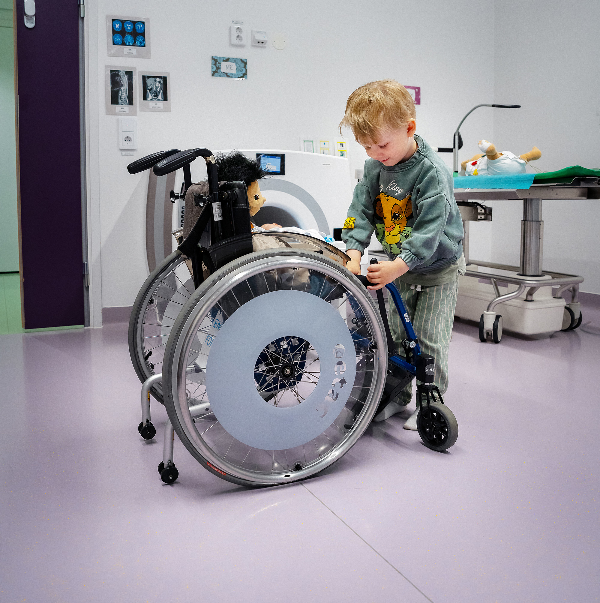 A child playing with a doll in a wheelchair.