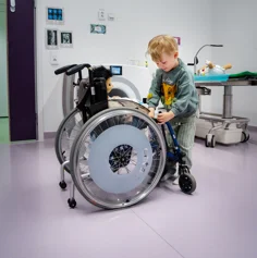 A child playing with a doll in a wheelchair.