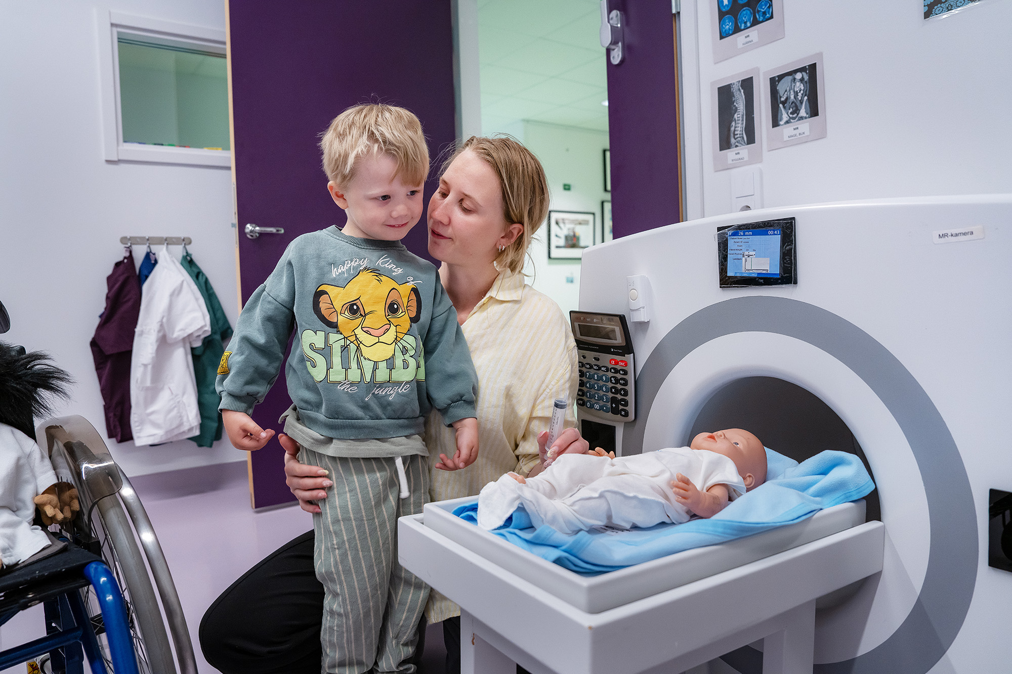 A mother and child with a toy MRI machine.