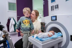 A mother and child with a toy MRI machine.